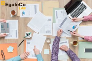 equipo de trabajo simulando trabajar en un plan de igualdad con material de oficina