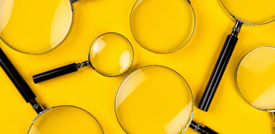 Lupas sobre fondo amarillo que representan la revisión de información disponible para elaborar un diagnóstico de políticas públicas